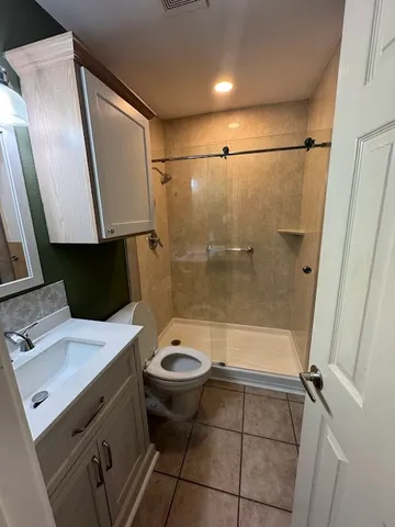 a bathroom with a sink a toilet a mirror and shower