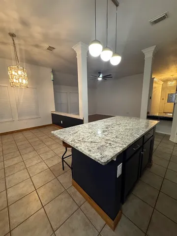 a kitchen with a sink a chandelier and living room view