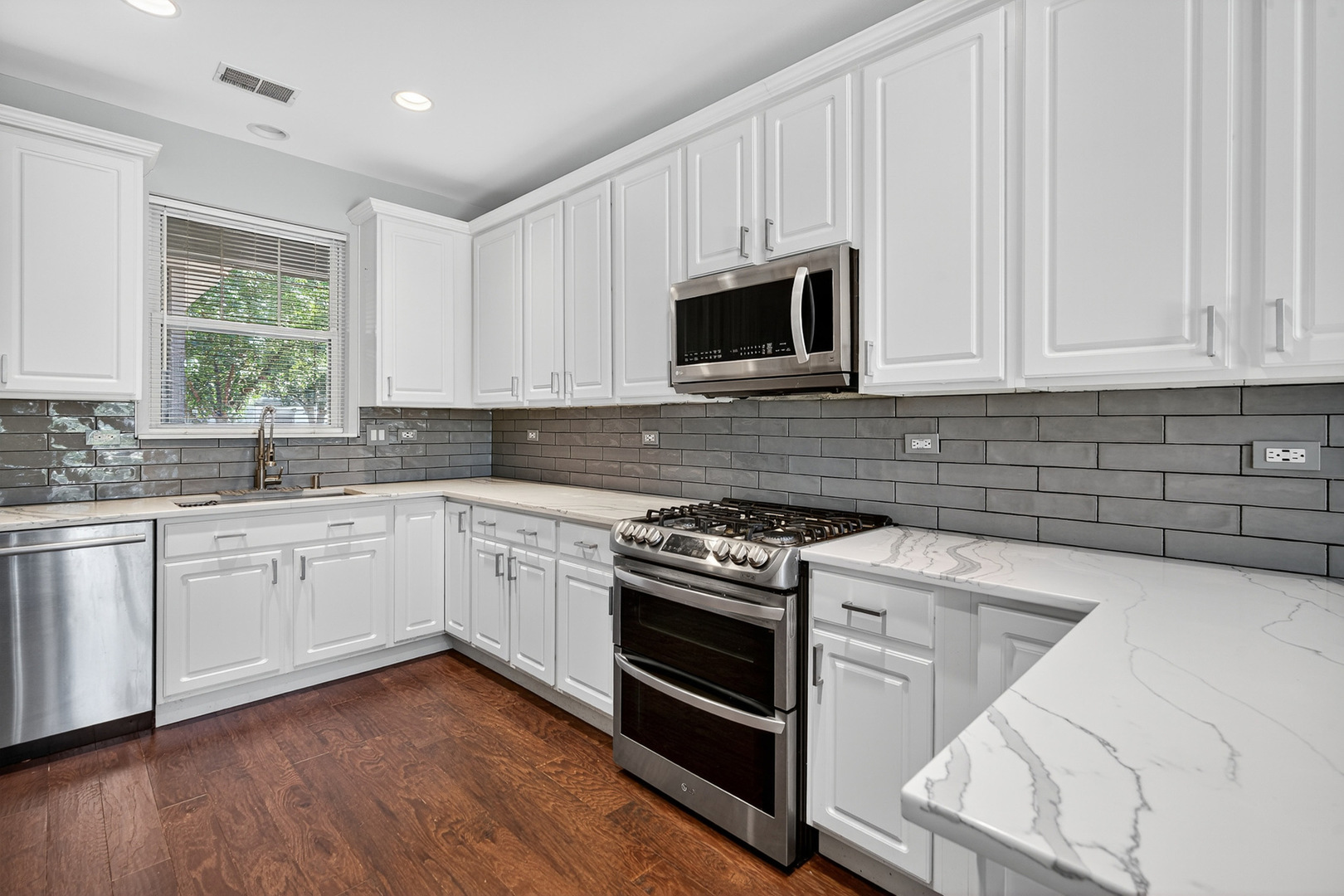 2870 Glacier Way, Unit B Wauconda, IL 60084 - Photo 8 of 35 a kitchen with granite countertop white cabinets appliances a sink and a window
