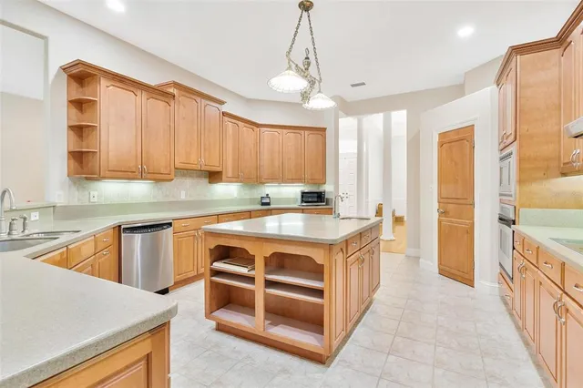 a large kitchen with stainless steel appliances granite countertop a stove a sink dishwasher and a refrigerator