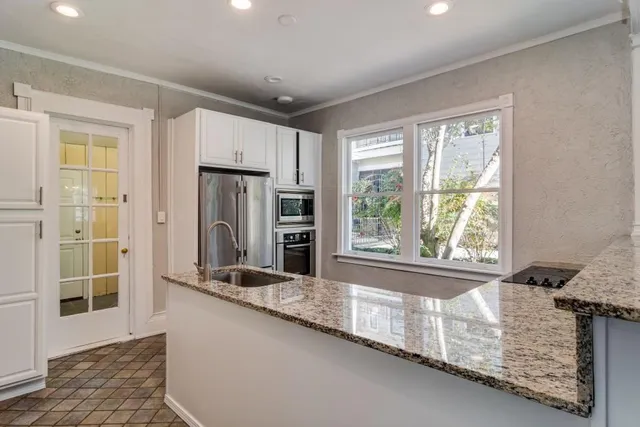 a kitchen with stainless steel appliances granite countertop a sink a stove and a refrigerator