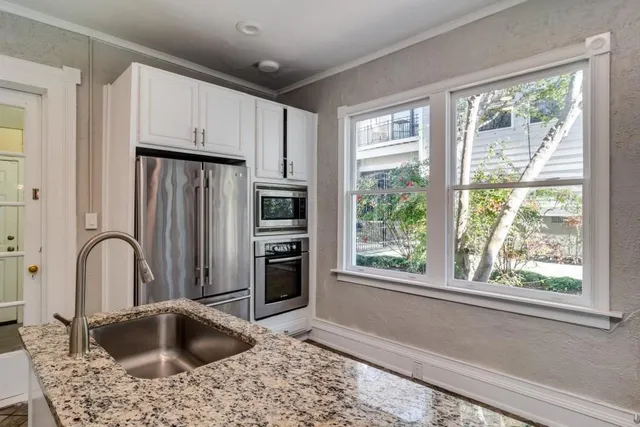 a kitchen with stainless steel appliances granite countertop a refrigerator sink and stove