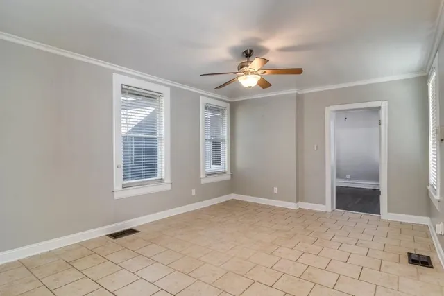 an empty room with windows and fan