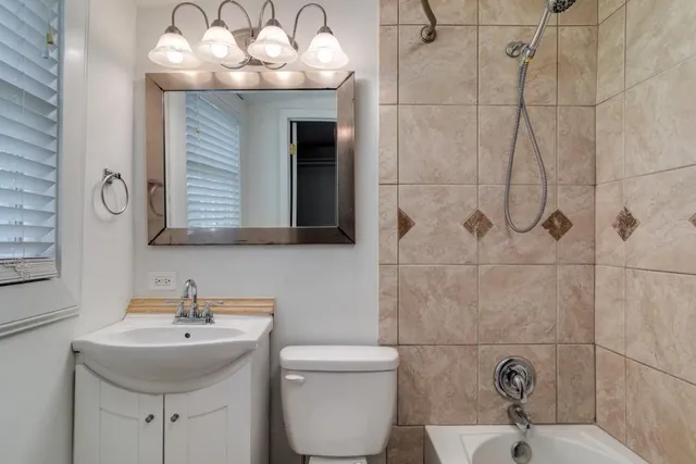 a bathroom with a sink a toilet and mirror