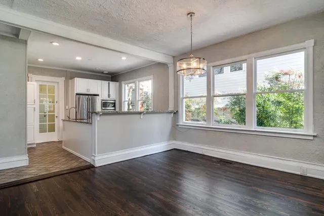 a view of a kitchen with wooden floor and a window