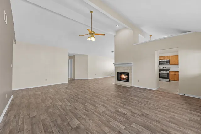 a view of empty room with wooden floor and fireplace
