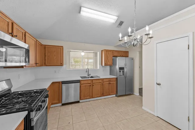 a kitchen with stainless steel appliances granite countertop a sink and a refrigerator