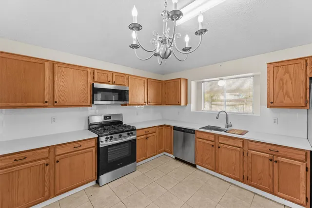 a kitchen with stainless steel appliances granite countertop a sink dishwasher stove and microwave with wooden floor