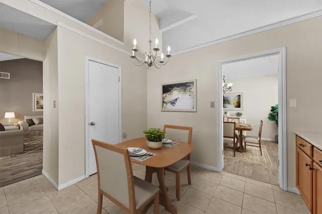 a view of a dining room with furniture and chandelier