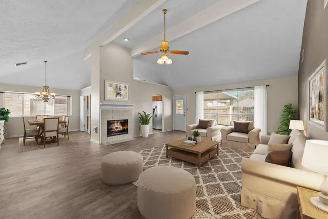 a living room with furniture a fireplace and a chandelier