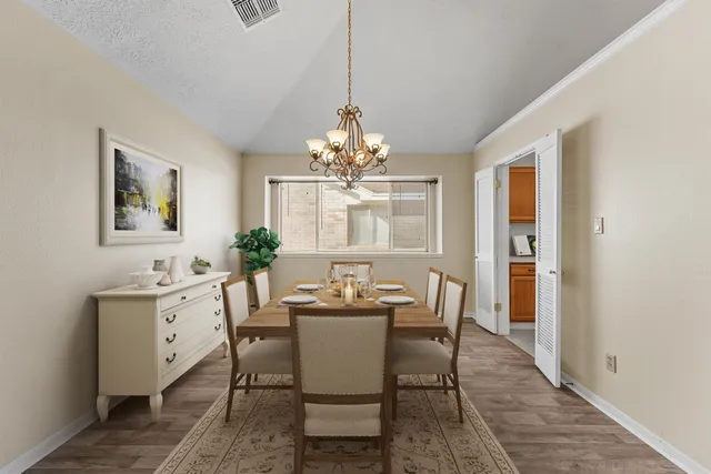 a dining room with furniture a chandelier and wooden floor