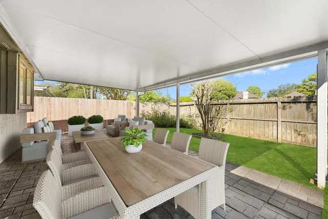 a view of an outdoor dining space with a table and chairs