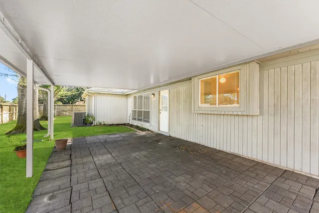 a view of a backyard with table and chairs and wooden fence
