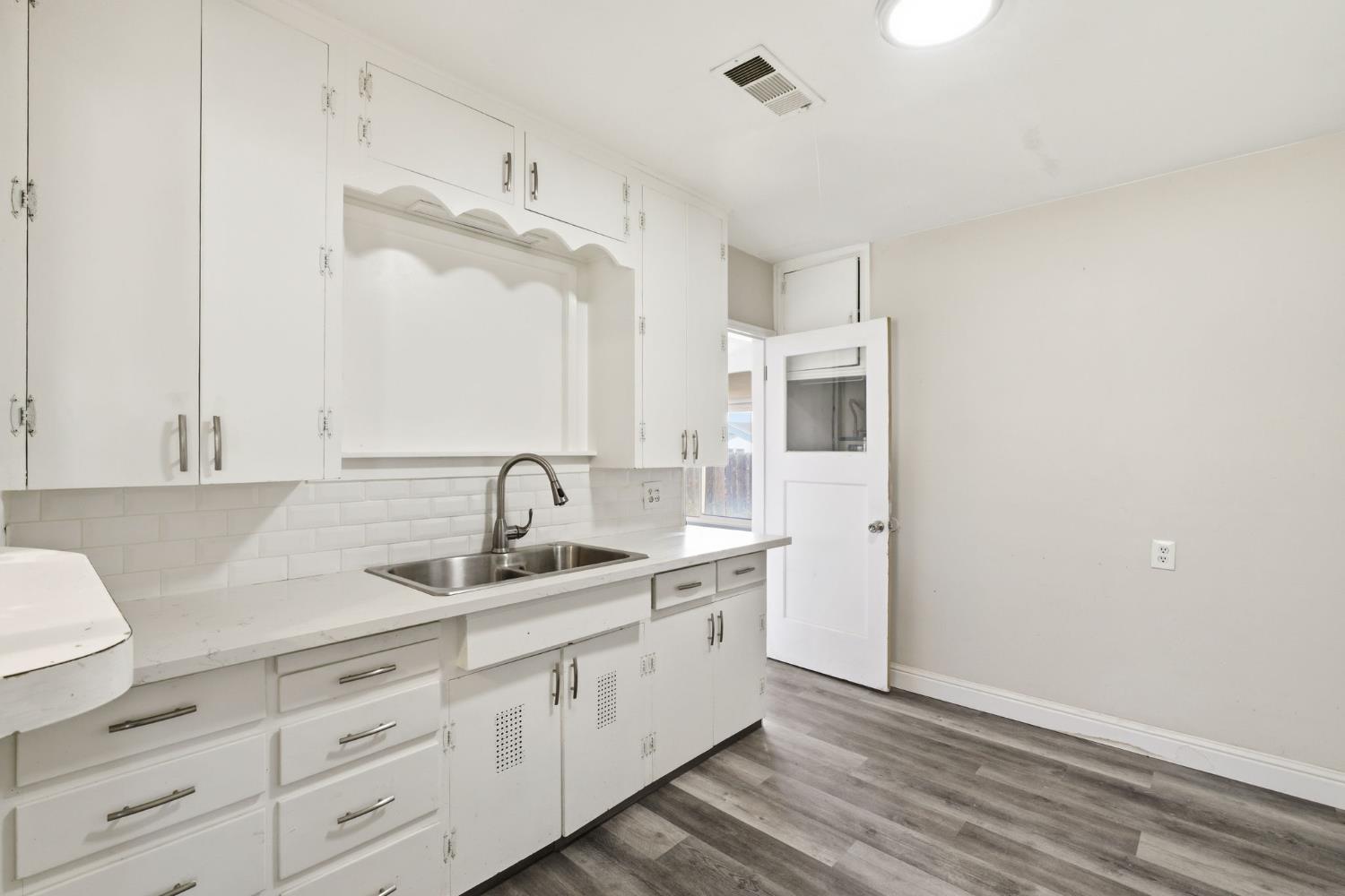 133 Oleander Avenue Lemoore, CA 93245 - Photo 12 of 30 a bathroom with a double vanity sink a mirror and a bathtub