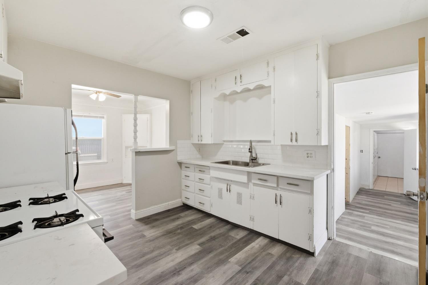 133 Oleander Avenue Lemoore, CA 93245 - Photo 13 of 30 a kitchen with a stove a sink and a refrigerator