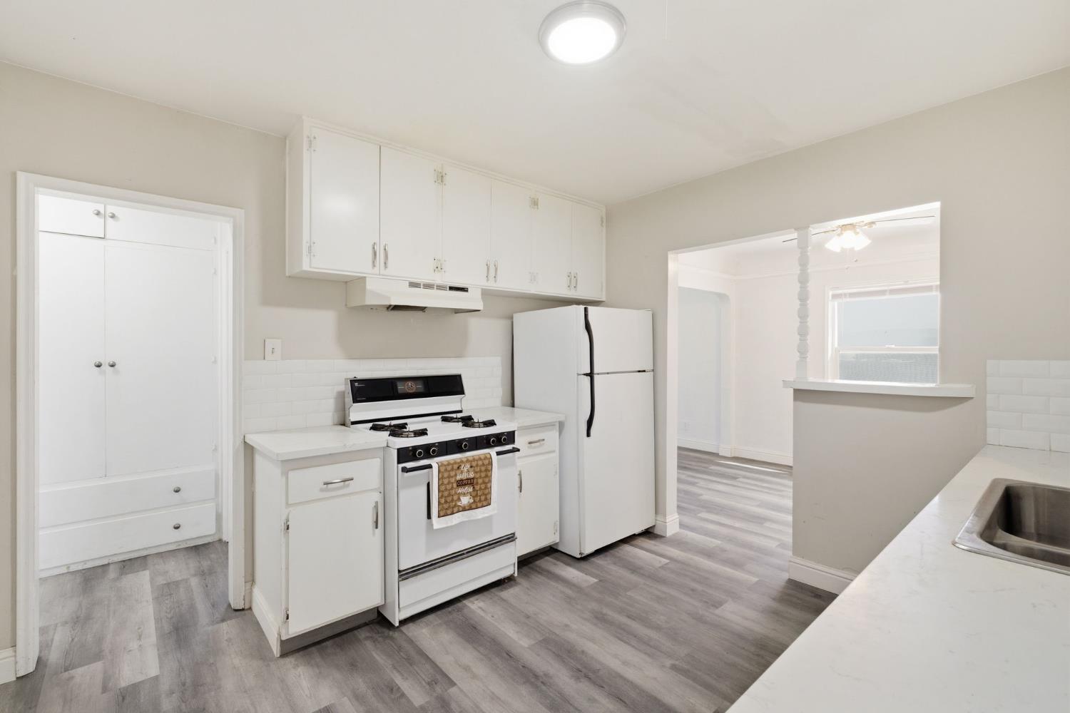 133 Oleander Avenue Lemoore, CA 93245 - Photo 14 of 30 a kitchen with cabinets and wooden floor