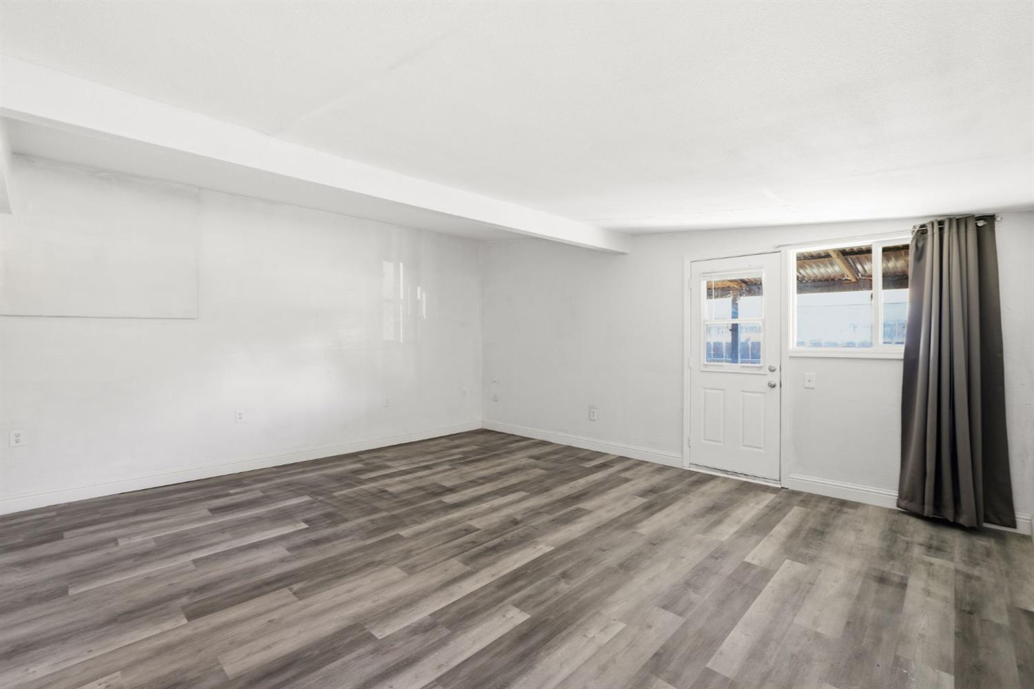 133 Oleander Avenue Lemoore, CA 93245 - Photo 22 of 30 a view of empty room with wooden floor and fan