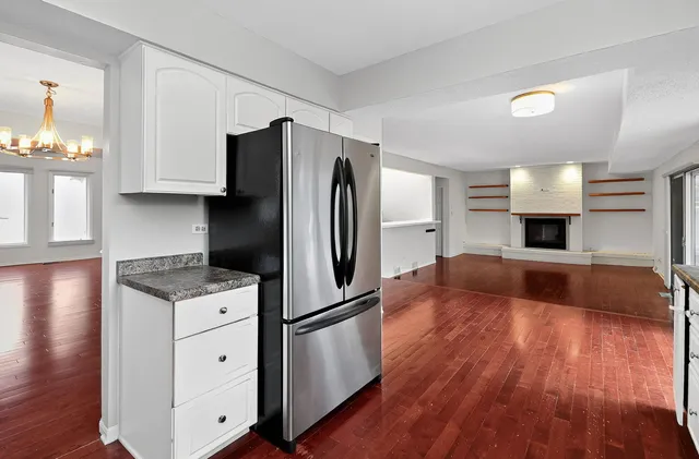 a kitchen with granite countertop a refrigerator and a stove top oven