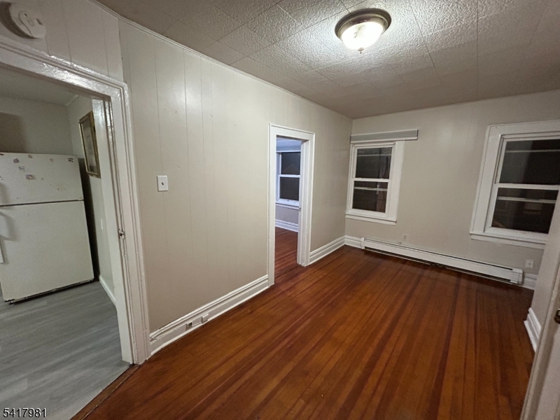 184 Walnut Street Newark, NJ 07105 - Photo 2 of 11 an empty room with wooden floor and windows