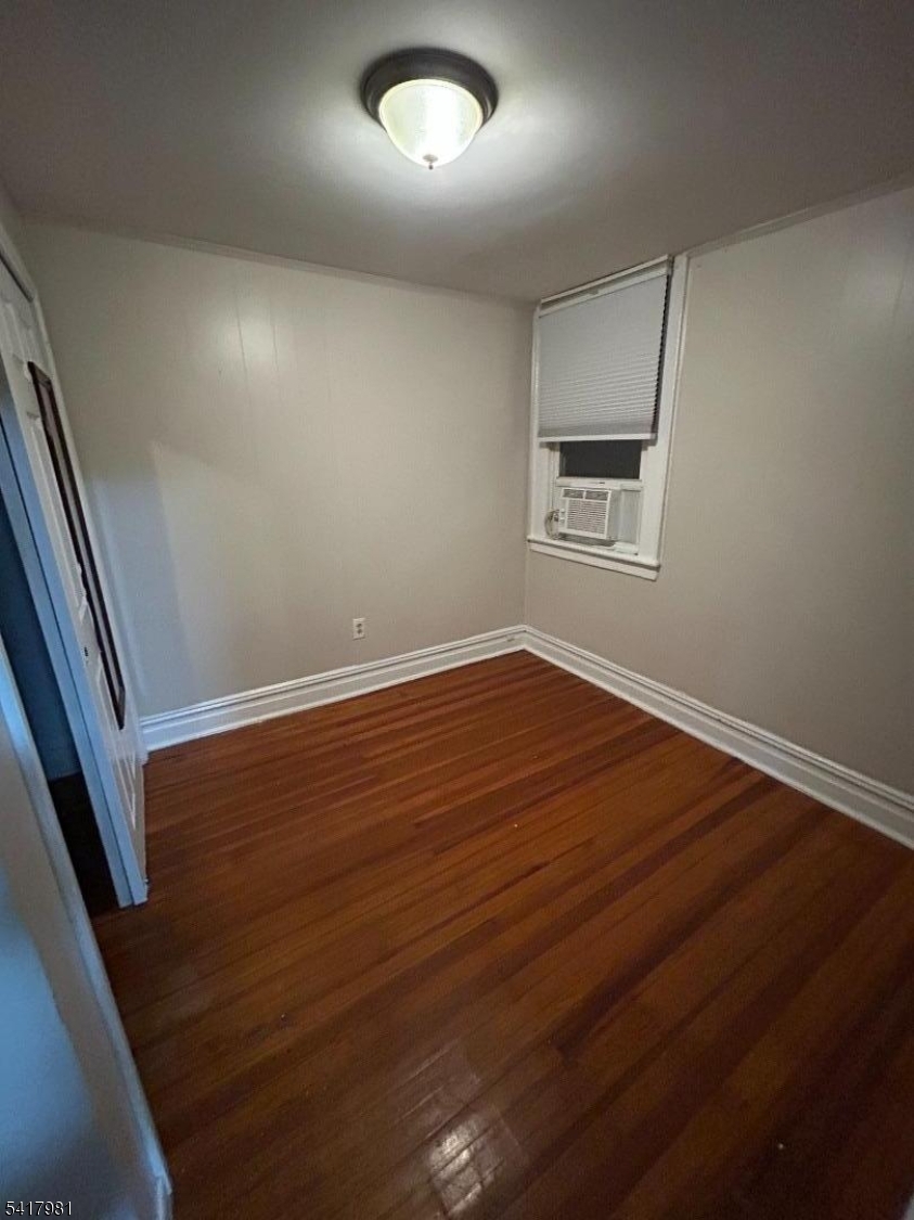 184 Walnut Street Newark, NJ 07105 - Photo 8 of 11 an empty room with wooden floor and windows