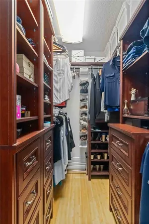 a view of walk in closet with clothes and shoes