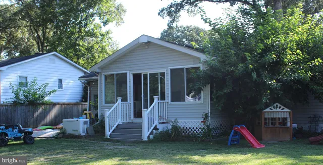 a view of a house with backyard and a tree