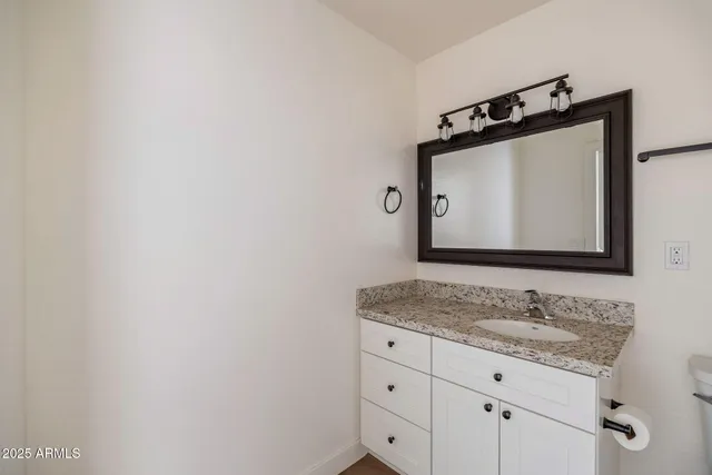 a bathroom with a granite countertop sink and a mirror