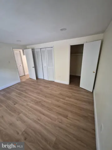a view of an empty room with wooden floor and stairs