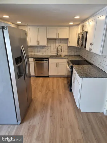 a kitchen with a sink a refrigerator a microwave and cabinets