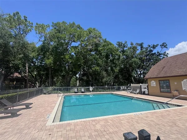 a view of backyard with swimming pool and seating space