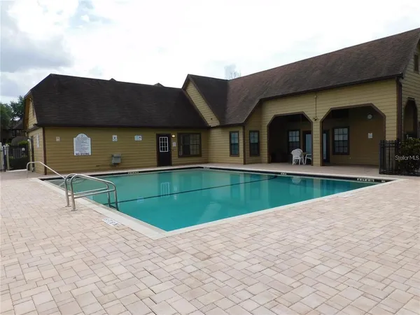 a view of a house with a swimming pool and a yard