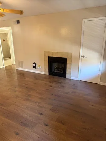 a view of a livingroom with wooden floor and a fireplace
