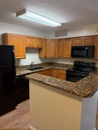 a kitchen with stainless steel appliances granite countertop a stove a sink dishwasher and a refrigerator