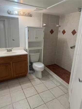 a bathroom with a sink a toilet and shower