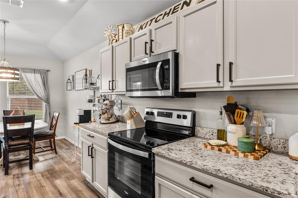 7121 Guadalupe Road Waco, TX 76633 - Photo 13 of 38 a kitchen with stainless steel appliances granite countertop a stove a sink and a microwave