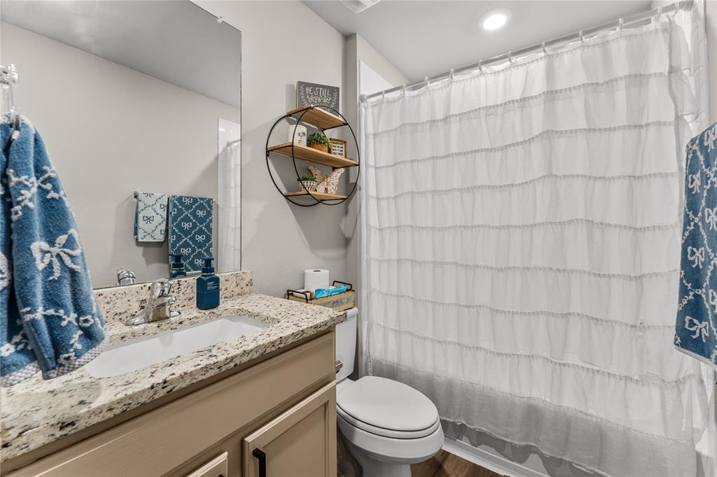 7121 Guadalupe Road Waco, TX 76633 - Photo 30 of 38 a bathroom with a granite countertop sink mirror vanity and toilet