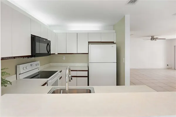 a kitchen with granite countertop a refrigerator and a sink