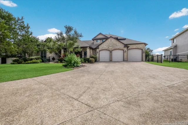 a view of a house with a yard and large trees