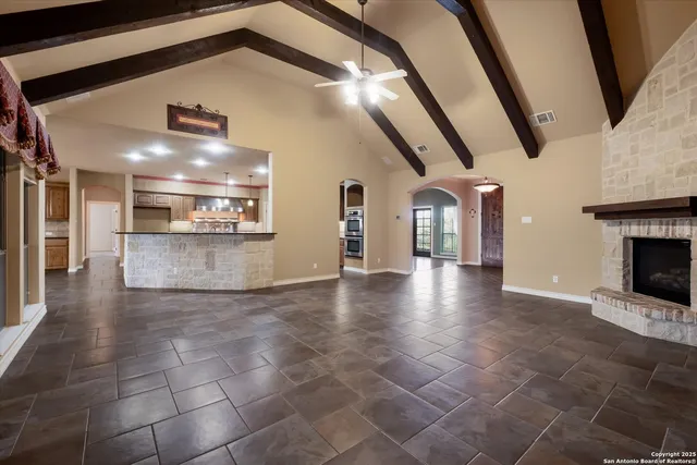 an empty room with windows and ceiling fan