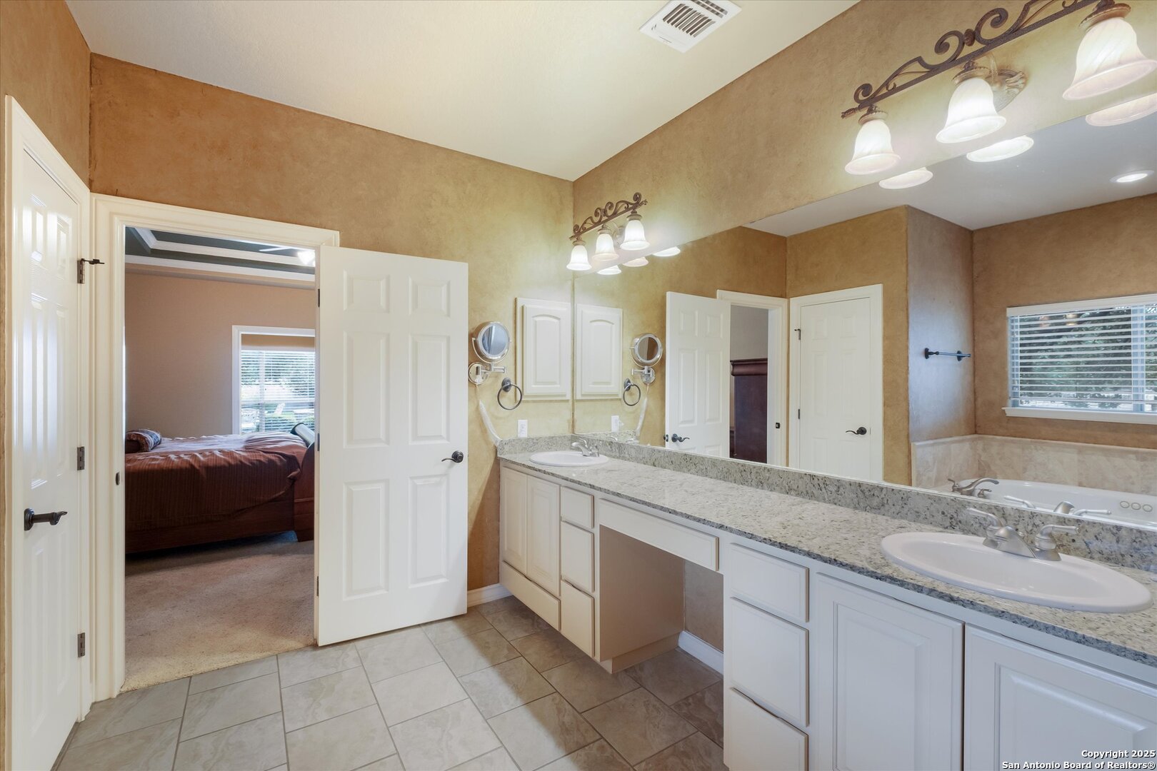 611 Ridge San Antonio, TX 78258 - Photo 23 of 42 a spacious bathroom with a granite countertop sink a mirror and a bathtub