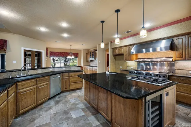 a kitchen with stainless steel appliances granite countertop a stove and a sink