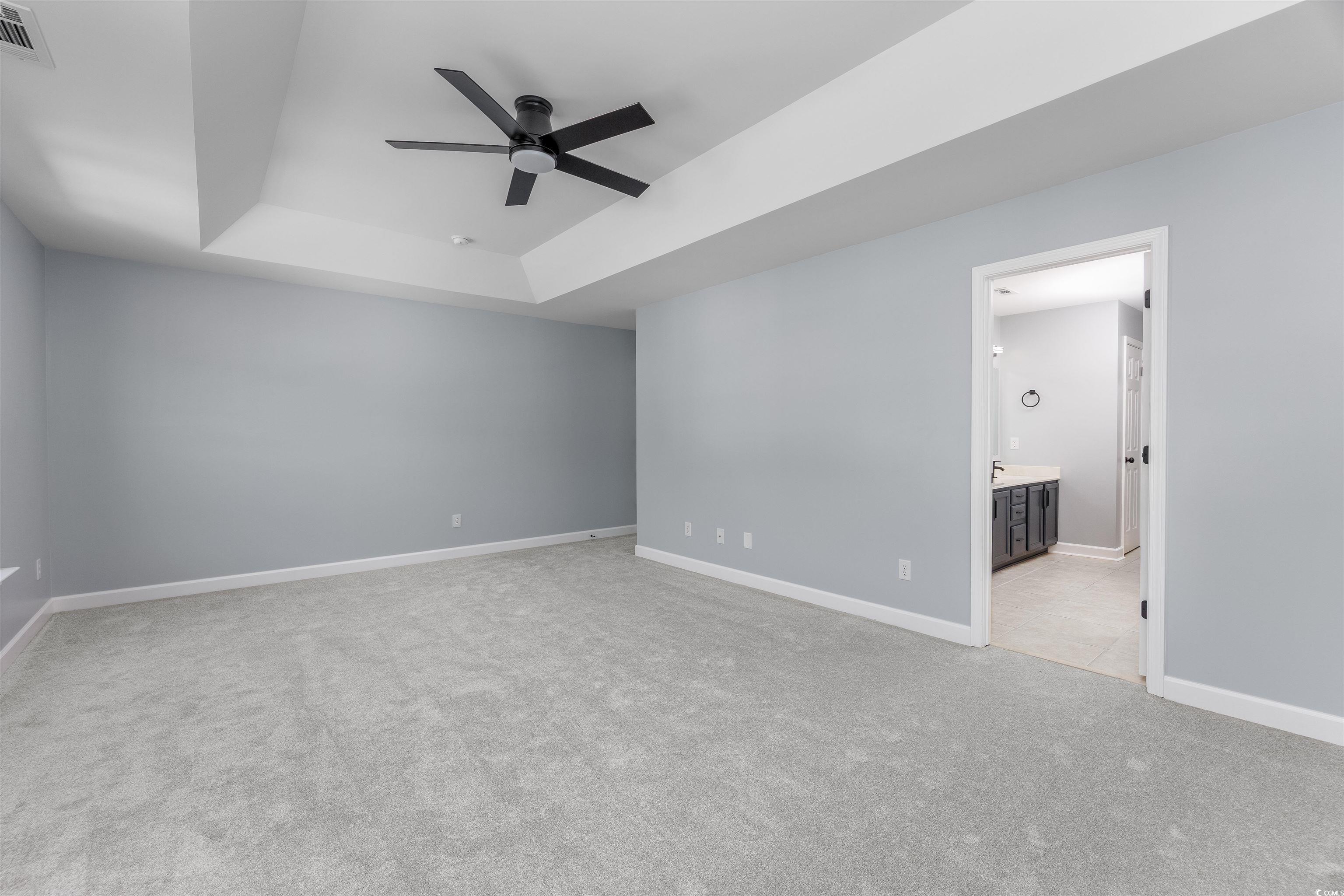 1031 Snowberry Drive Longs, SC 29568 - Photo 33 of 38 Unfurnished bedroom with a raised ceiling, light colored carpet, a ceiling fan, and ensuite bath