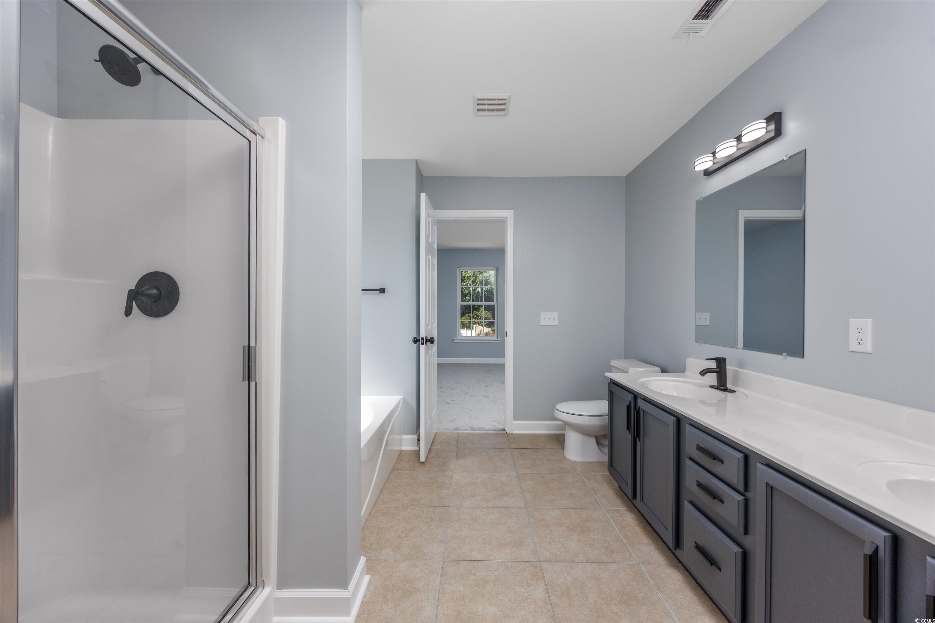 1031 Snowberry Drive Longs, SC 29568 - Photo 37 of 38 Bathroom with a garden tub, a shower stall, and light tile patterned flooring
