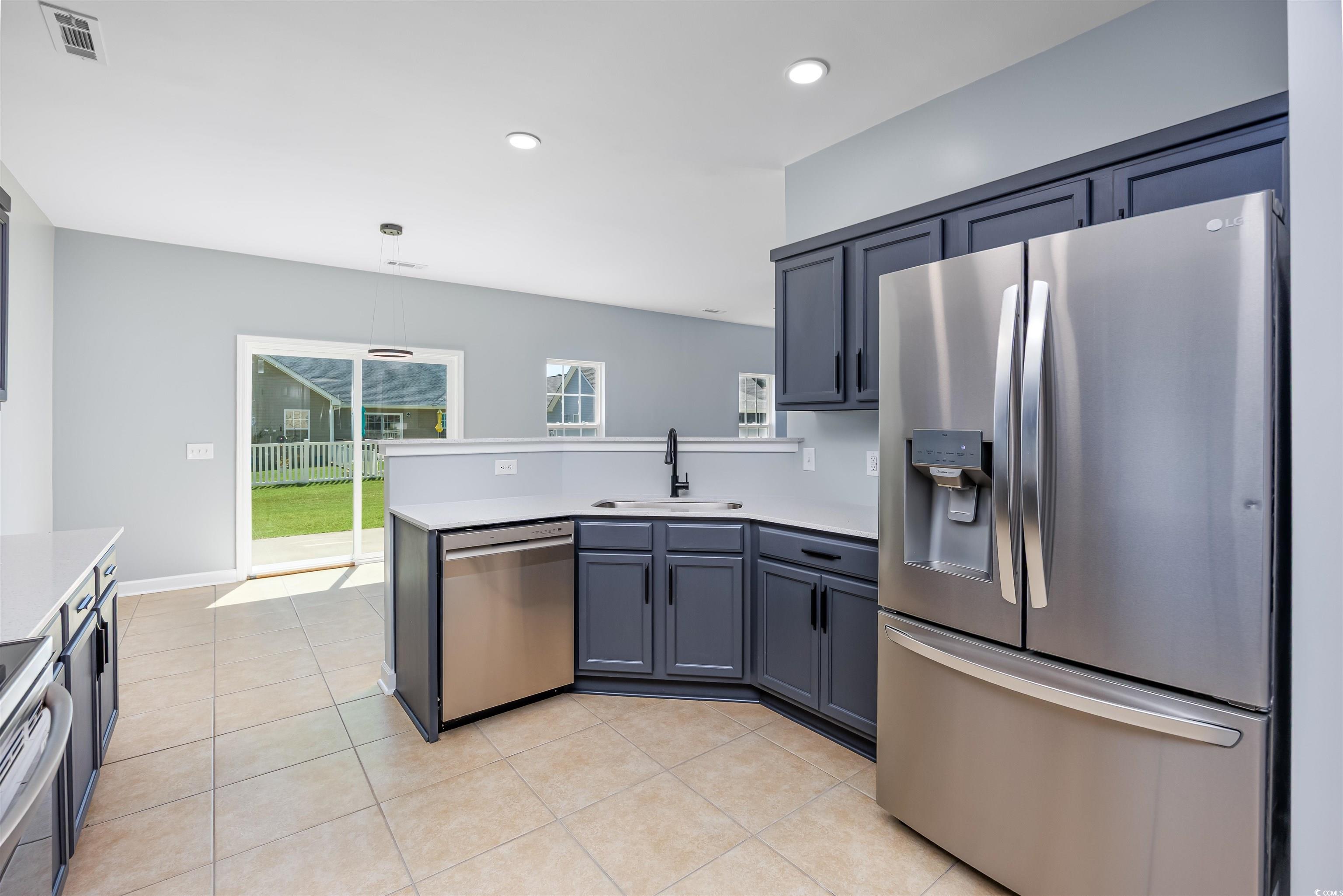 1031 Snowberry Drive Longs, SC 29568 - Photo 9 of 38 Kitchen with stainless steel appliances, light tile patterned flooring, light countertops, recessed lighting, and a peninsula