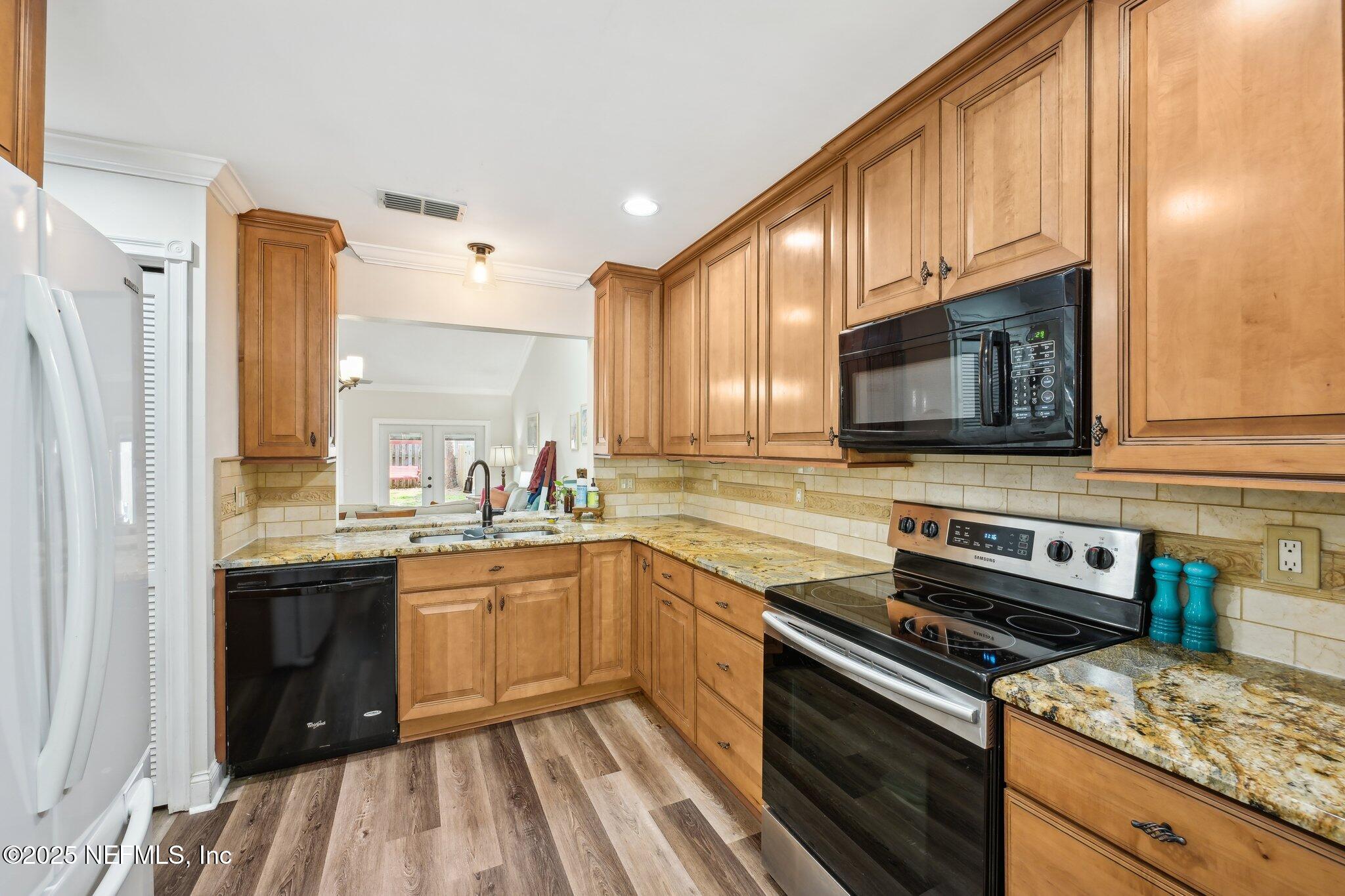 585 Pine Forest Trail Orange Park, FL 32073 - Photo 18 of 52 a kitchen with stainless steel appliances granite countertop a sink stove microwave and refrigerator