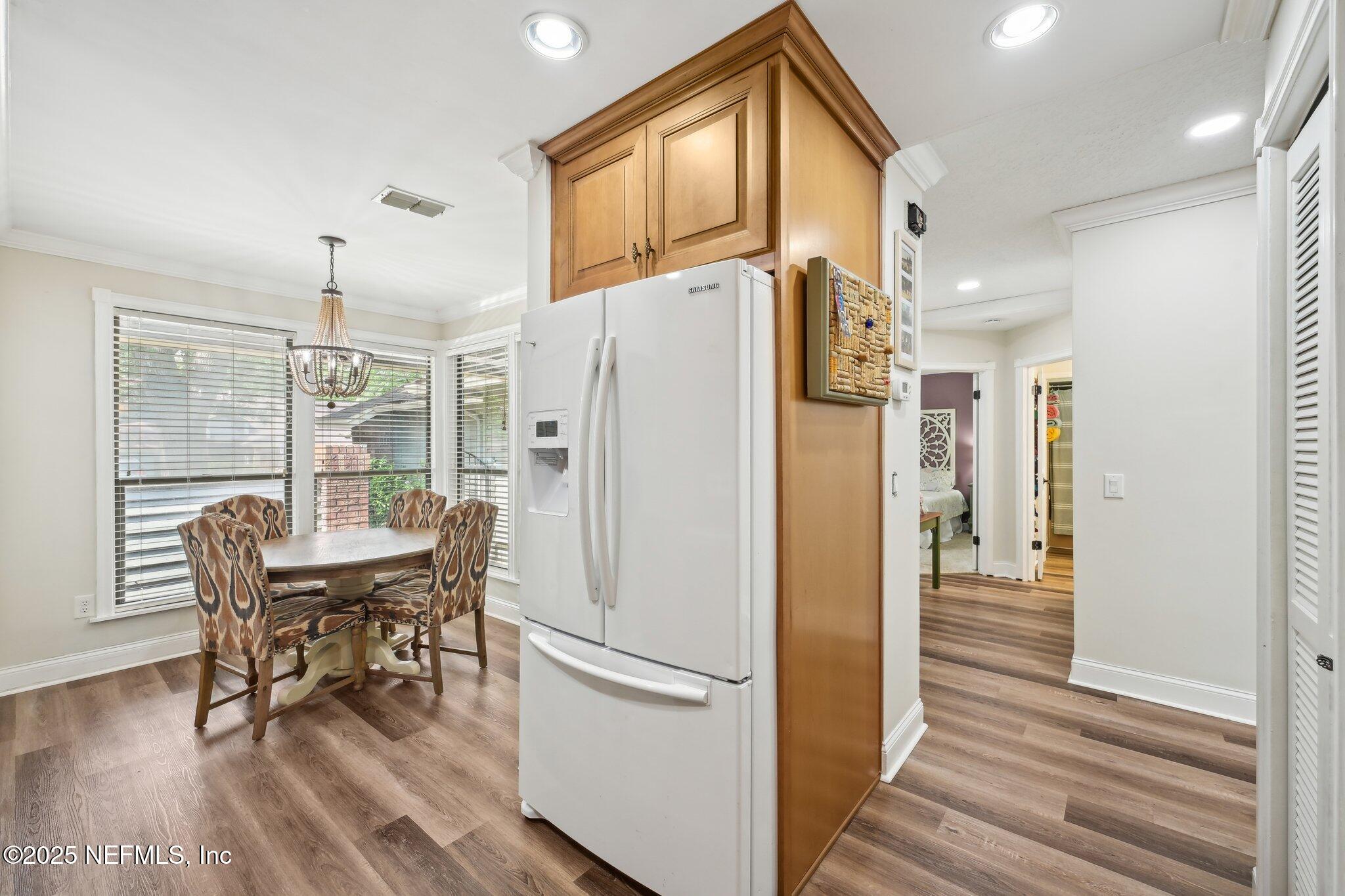 585 Pine Forest Trail Orange Park, FL 32073 - Photo 20 of 52 a dining room with stainless steel appliances a dining table chairs and chandelier