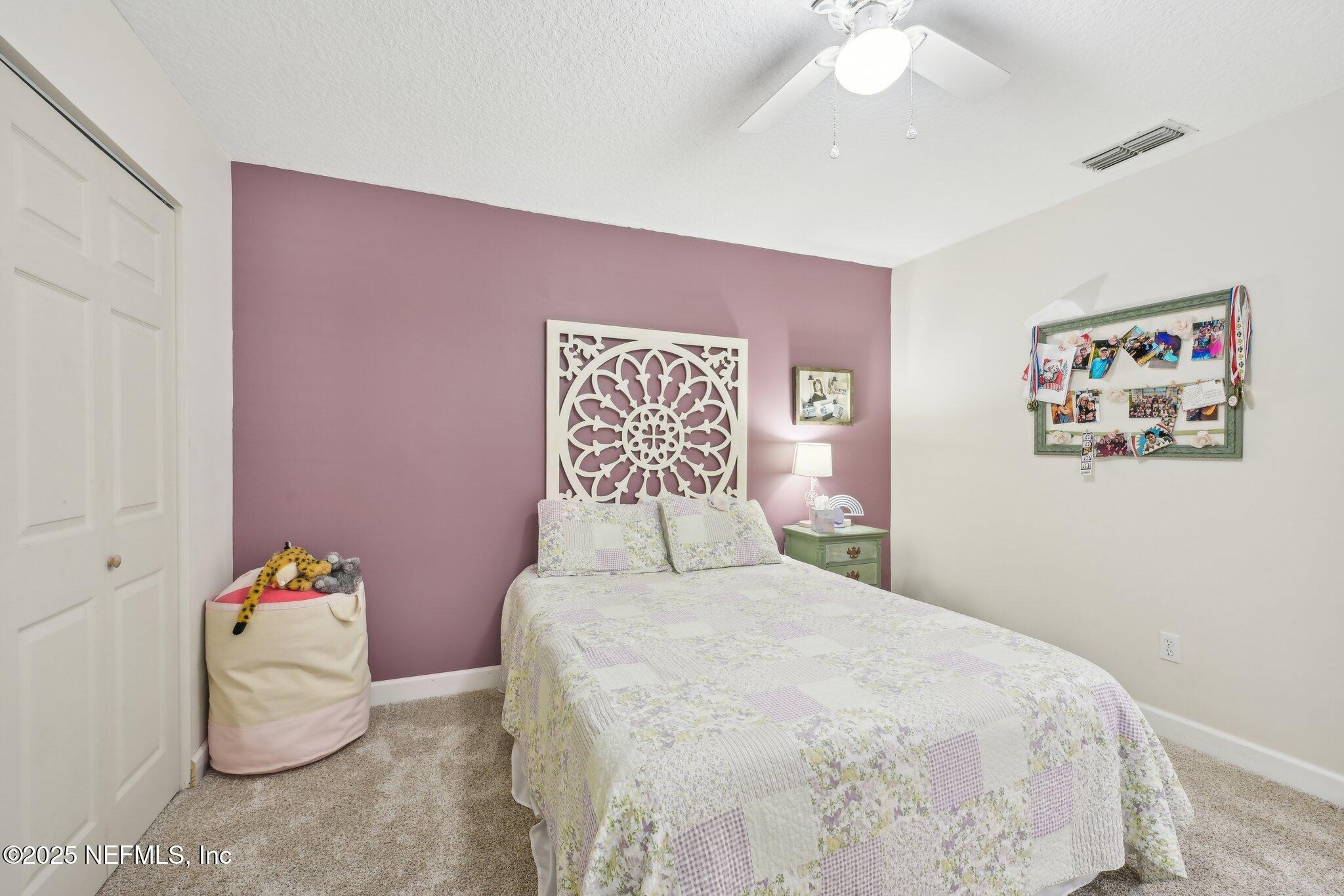 585 Pine Forest Trail Orange Park, FL 32073 - Photo 24 of 52 a bedroom with a bed and a chandelier