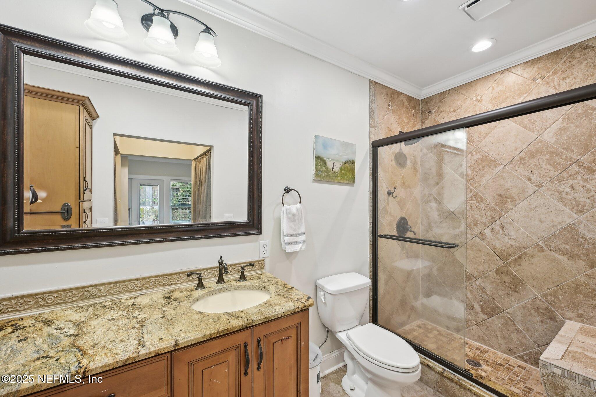 585 Pine Forest Trail Orange Park, FL 32073 - Photo 34 of 52 a bathroom with a granite countertop sink toilet a mirror and shower
