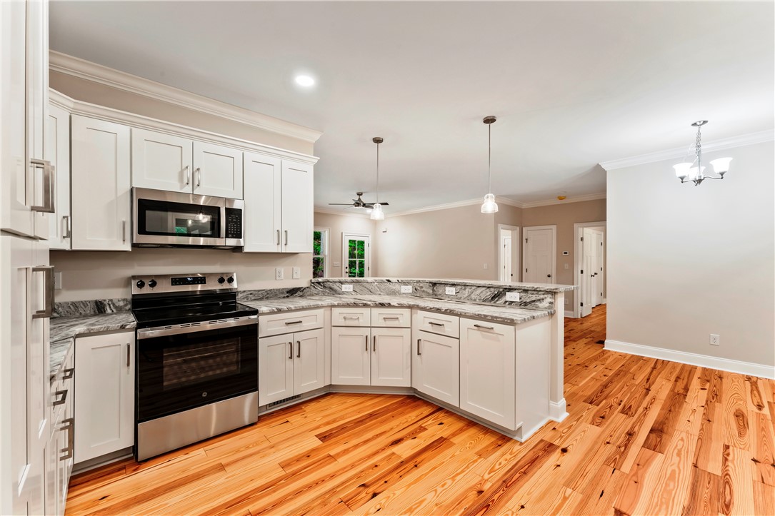 110 Gabriel Way Pickens, SC 29671 - Photo 8 of 48 A well-equipped kitchen features bright white cabinetry and gorgeous granite counters, seamlessly connecting to living spaces.