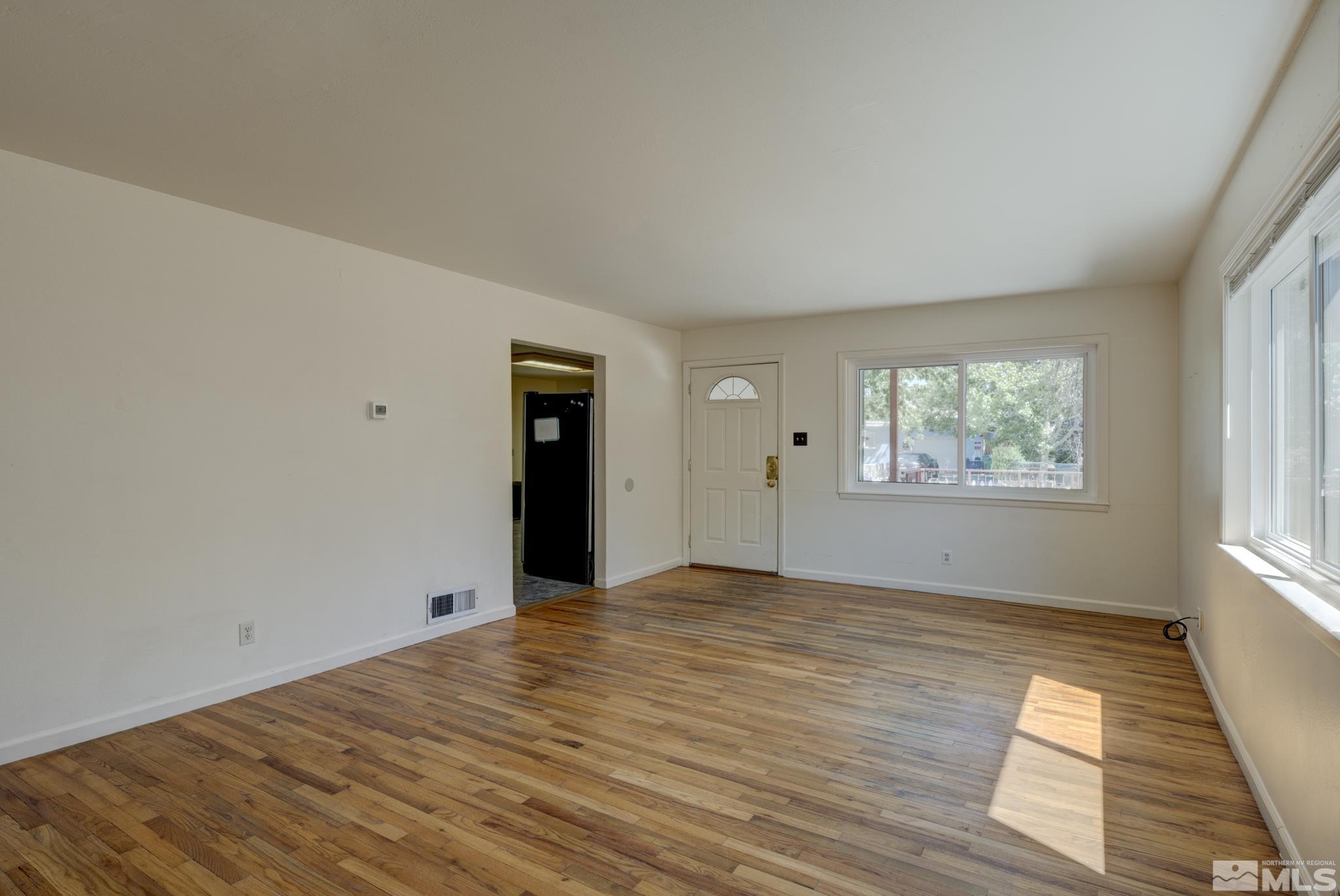 1890 Trainer Way Reno, NV 89512 - Photo 7 of 19 a view of an empty room with wooden floor and a window
